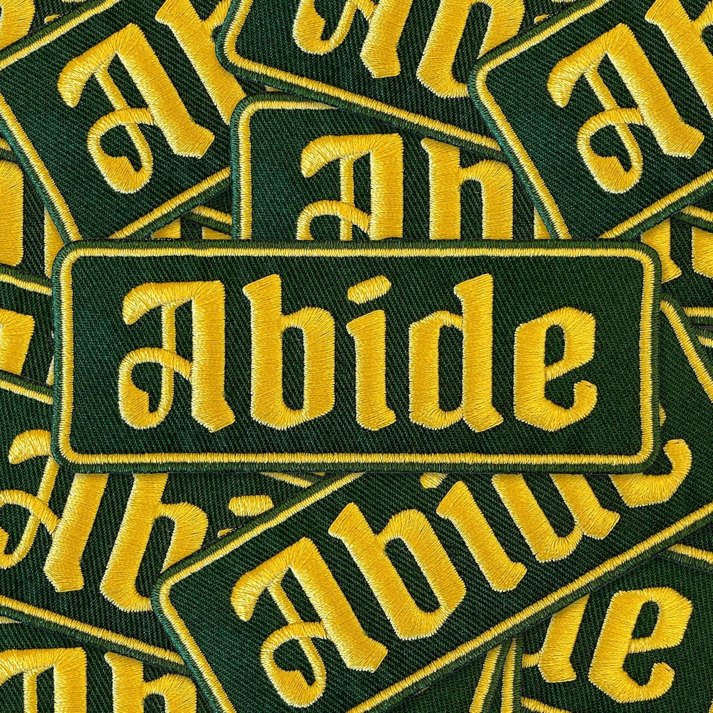 ABIDE Embroidered Patch - Iron-On Patch 4" x 1.5" - Green & Gold Gothic Font Great for Trucker Hats